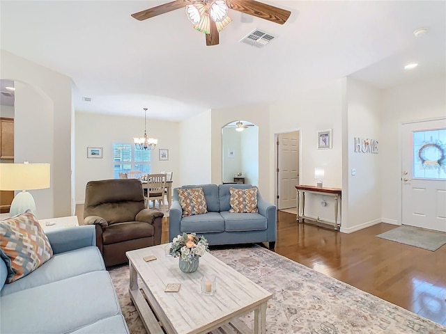 501 Heartwell Dr, Poinciana, FL 34759 - living room featuring visible vents, baseboards, wood finished floors, arched walkways, and ceiling fan with notable chandelier