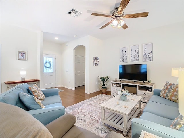 501 Heartwell Dr, Poinciana, FL 34759 - living area featuring baseboards, arched walkways, ceiling fan, visible vents, and wood finished floors