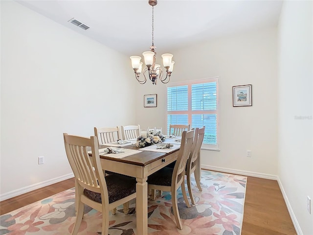 501 Heartwell Dr, Poinciana, FL 34759 - dining room featuring baseboards, visible vents, a notable chandelier, and wood finished floors