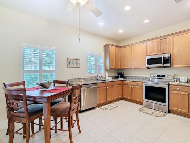 501 Heartwell Dr, Poinciana, FL 34759 - kitchen featuring a ceiling fan, a sink, appliances with stainless steel finishes, and light stone counters