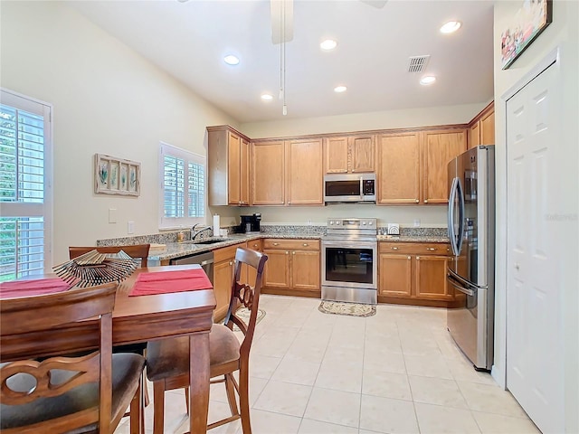 501 Heartwell Dr, Poinciana, FL 34759 - kitchen with recessed lighting, a sink, light stone counters, visible vents, and appliances with stainless steel finishes