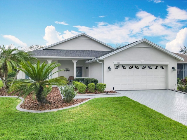 501 Heartwell Dr, Poinciana, FL 34759 - ranch-style home with stucco siding, an attached garage, decorative driveway, a front lawn, and a shingled roof