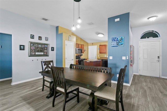 323 Azincourt Ln, Kissimmee, FL 34759 - dining space with baseboards, lofted ceiling, visible vents, and wood finished floors