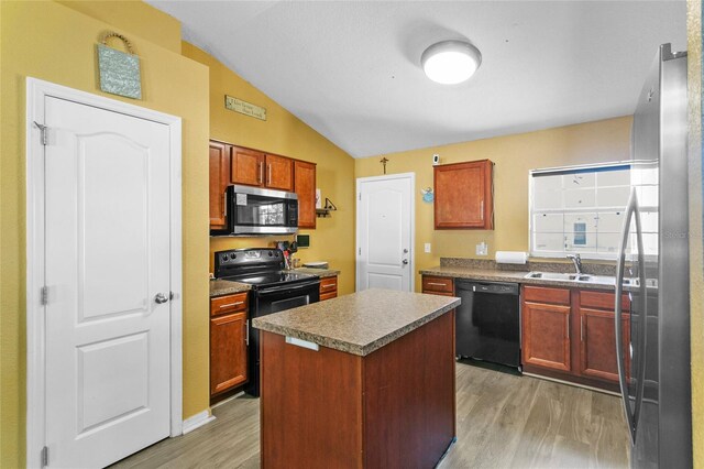 323 Azincourt Ln, Kissimmee, FL 34759 - kitchen with a sink, a kitchen island, lofted ceiling, black appliances, and light wood-style floors