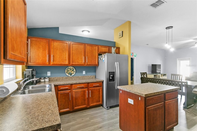 323 Azincourt Ln, Kissimmee, FL 34759 - kitchen with visible vents, stainless steel fridge, a kitchen island, a sink, and light wood-type flooring