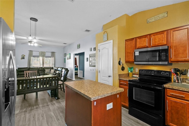 323 Azincourt Ln, Kissimmee, FL 34759 - kitchen with a kitchen island, a ceiling fan, light wood-type flooring, stainless steel appliances, and visible vents