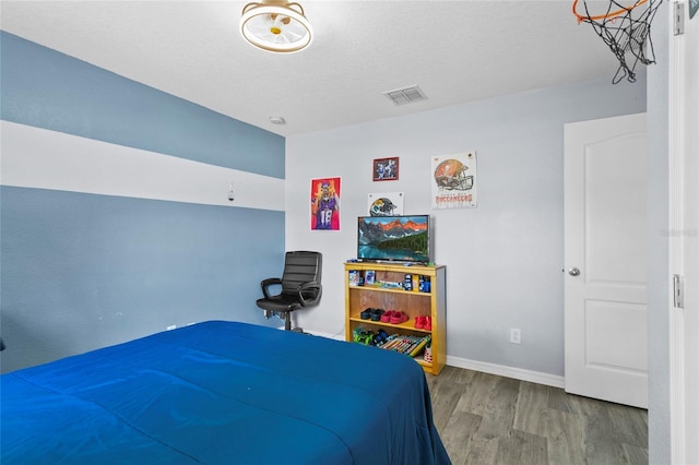 323 Azincourt Ln, Kissimmee, FL 34759 - bedroom featuring visible vents, a textured ceiling, baseboards, and wood finished floors