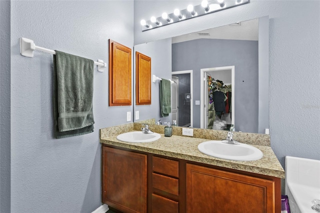 323 Azincourt Ln, Kissimmee, FL 34759 - full bathroom with double vanity, lofted ceiling, a sink, and a garden tub
