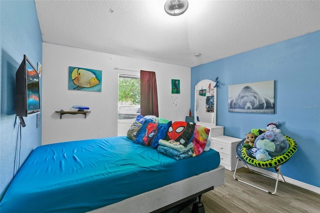 323 Azincourt Ln, Kissimmee, FL 34759 - bedroom with a textured ceiling, baseboards, and wood finished floors