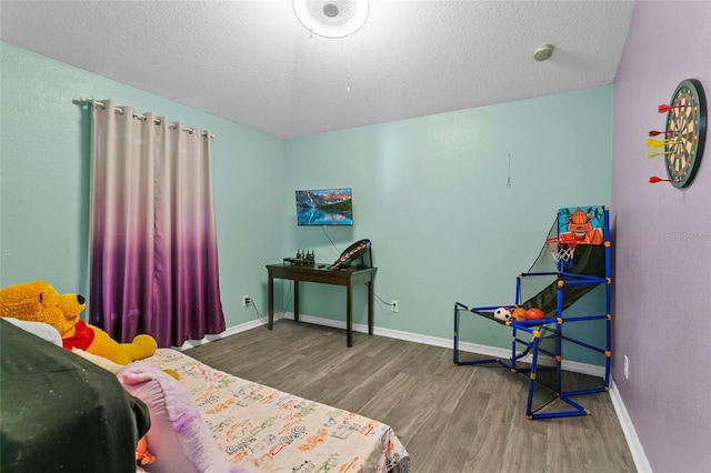 323 Azincourt Ln, Kissimmee, FL 34759 - bedroom featuring baseboards, a textured ceiling, and wood finished floors