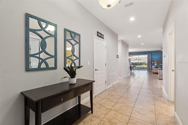 hall featuring light tile patterned flooring, baseboards, visible vents, and recessed lighting