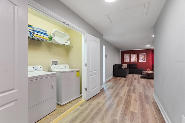 washroom featuring baseboards, laundry area, attic access, light wood-type flooring, and separate washer and dryer