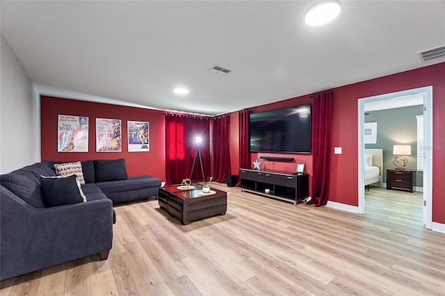 living area featuring wood finished floors, baseboards, and visible vents