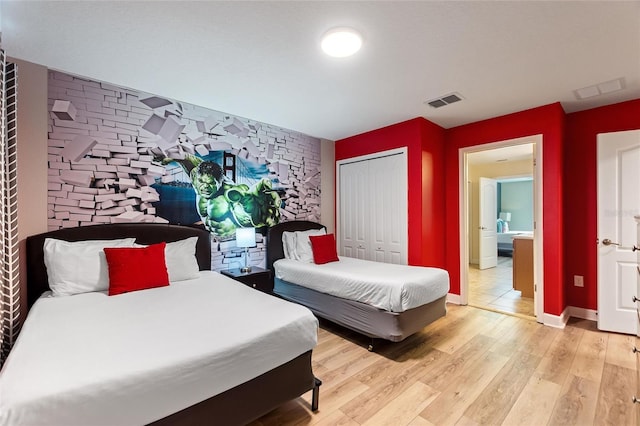 bedroom featuring baseboards, visible vents, a closet, and light wood-style floors