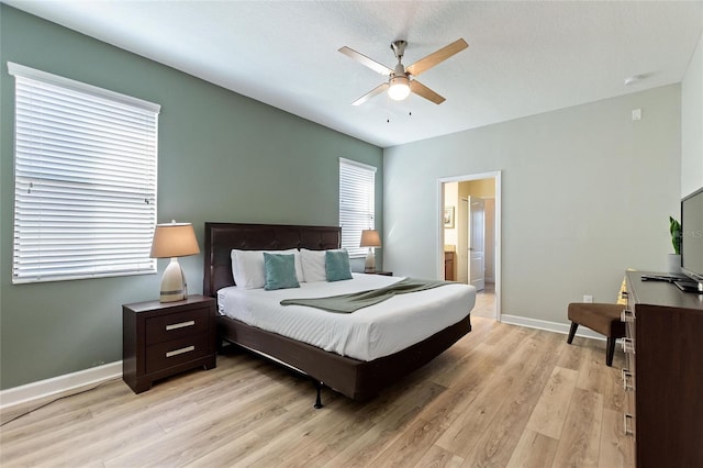 bedroom featuring baseboards, light wood-style floors, ceiling fan, and ensuite bathroom