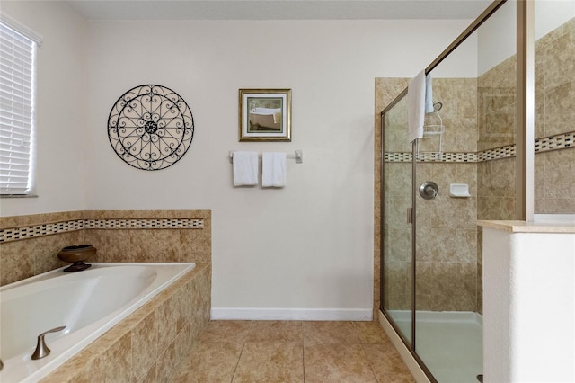 bathroom featuring tile patterned flooring, a stall shower, baseboards, and a garden tub