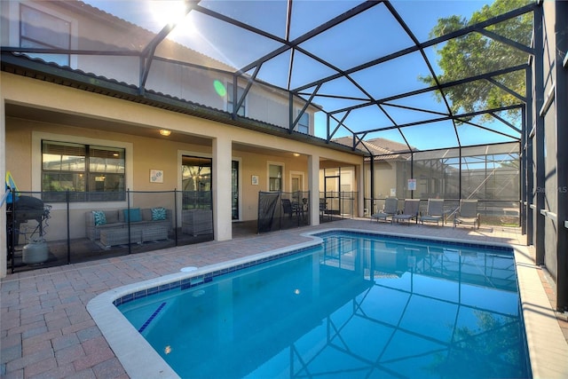 outdoor pool featuring a lanai, outdoor lounge area, and a patio area