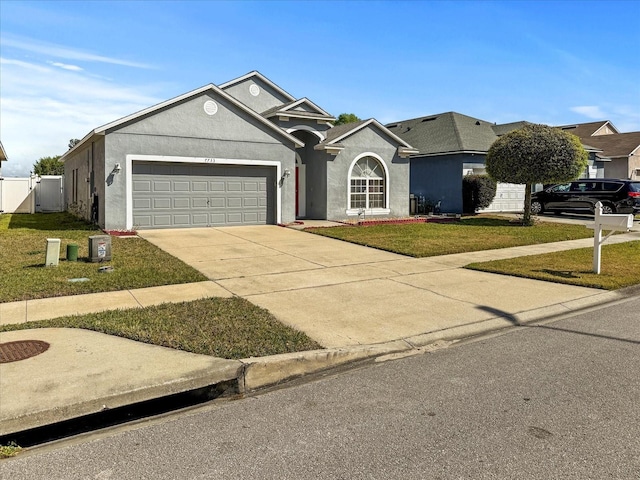 7733 Beridale Ct, Orlando, FL 32818 - view of front facade featuring concrete driveway, stucco siding, fence, an attached garage, and a front yard