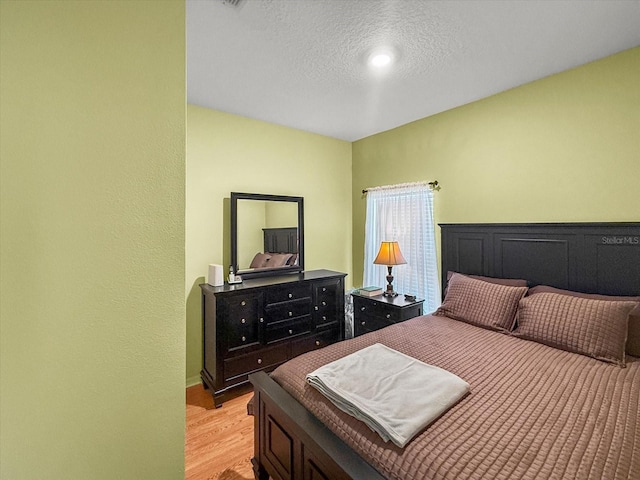 7733 Beridale Ct, Orlando, FL 32818 - bedroom featuring a textured ceiling and light wood finished floors
