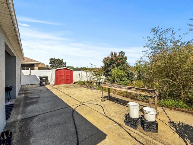 7733 Beridale Ct, Orlando, FL 32818 - view of patio / terrace featuring an outdoor structure, a fenced backyard, a shed, and grilling area