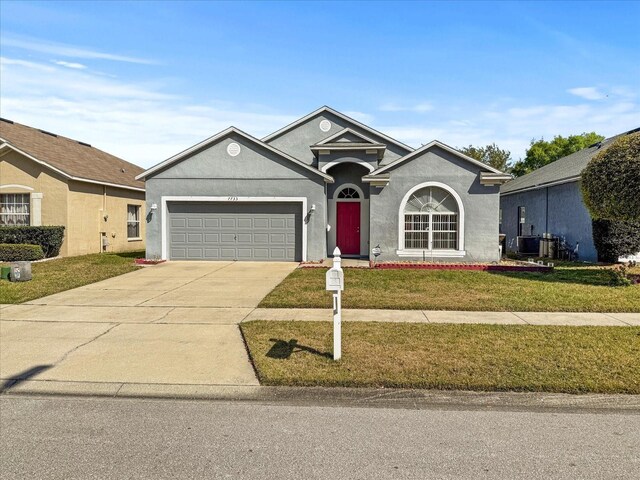 7733 Beridale Ct, Orlando, FL 32818 - ranch-style home with concrete driveway, stucco siding, an attached garage, central AC unit, and a front yard