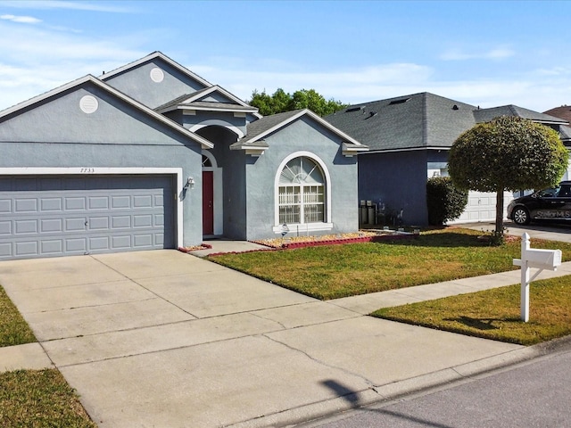 7733 Beridale Ct, Orlando, FL 32818 - single story home featuring concrete driveway, stucco siding, an attached garage, and a front lawn