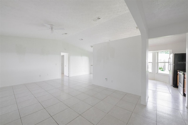 554 NW Twylite Ter, Port St Lucie, FL 34983 - spare room with vaulted ceiling, light tile patterned flooring, ceiling fan, and a textured ceiling