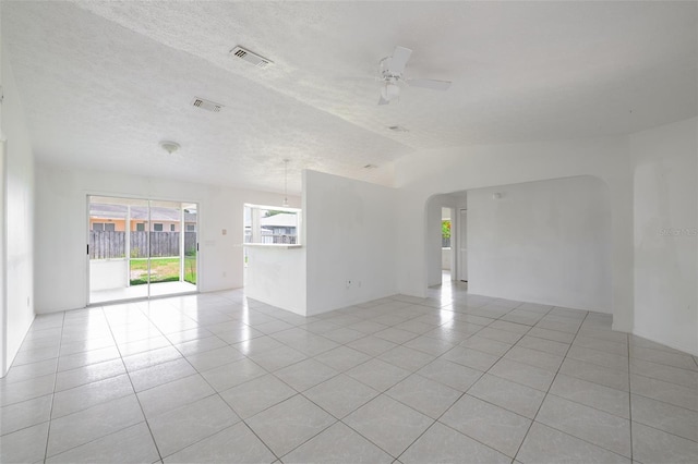 554 NW Twylite Ter, Port St Lucie, FL 34983 - empty room featuring light tile patterned floors, arched walkways, a ceiling fan, a textured ceiling, and lofted ceiling
