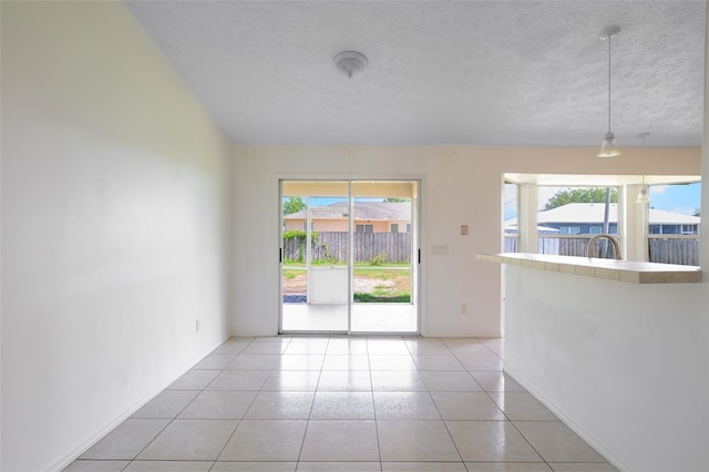 554 NW Twylite Ter, Port St Lucie, FL 34983 - empty room with healthy amount of natural light, light tile patterned floors, a textured ceiling, and baseboards