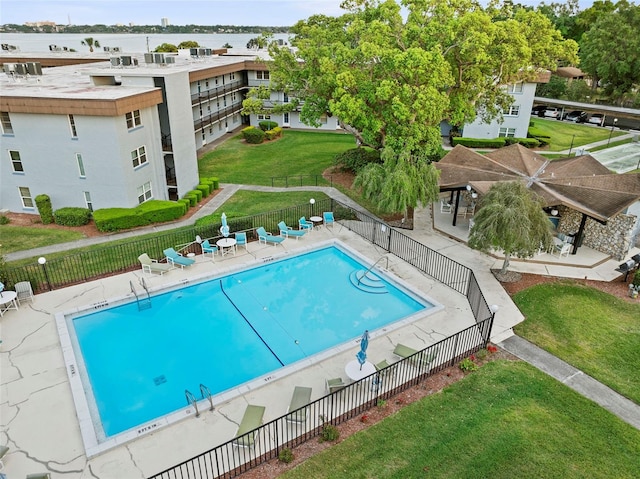 pool featuring a lawn, fence, and a patio area