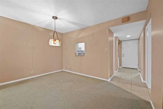 unfurnished room featuring baseboards, a textured ceiling, light tile patterned floors, and light carpet