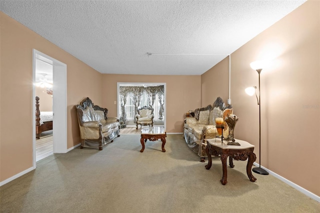 carpeted living room with baseboards and a textured ceiling