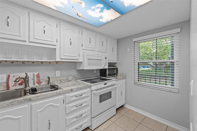 kitchen featuring light tile patterned flooring, light countertops, white appliances, white cabinetry, and a sink