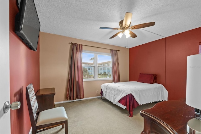 bedroom featuring baseboards, ceiling fan, carpet, and a textured ceiling