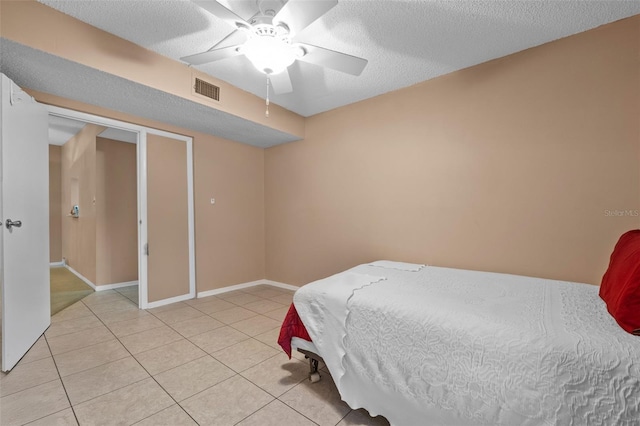 bedroom featuring light tile patterned floors, baseboards, a textured ceiling, ceiling fan, and visible vents