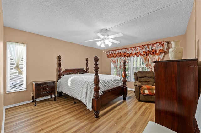 bedroom featuring baseboards, a textured ceiling, a ceiling fan, and light wood finished floors