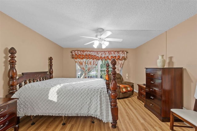bedroom featuring a ceiling fan, light wood finished floors, and a textured ceiling