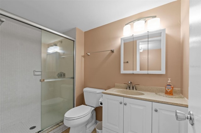 full bath with vanity, toilet, and a shower stall