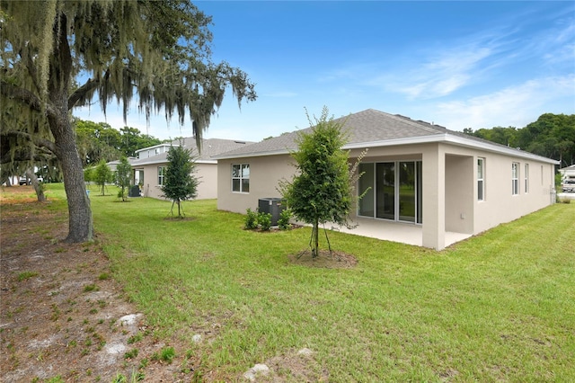 4083 Bannock Ave, Tavares, FL 32778 - back of property with stucco siding, a lawn, and a patio area