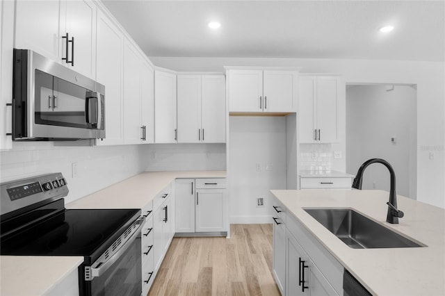 4083 Bannock Ave, Tavares, FL 32778 - kitchen featuring stainless steel appliances, recessed lighting, white cabinetry, light wood finished floors, and backsplash