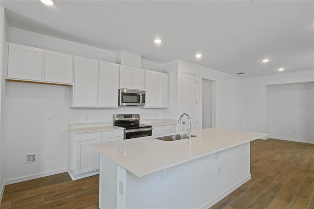 4079 Bannock Ave, Tavares, FL 32778 - kitchen with appliances with stainless steel finishes, dark wood-style flooring, recessed lighting, white cabinets, and a kitchen island with sink