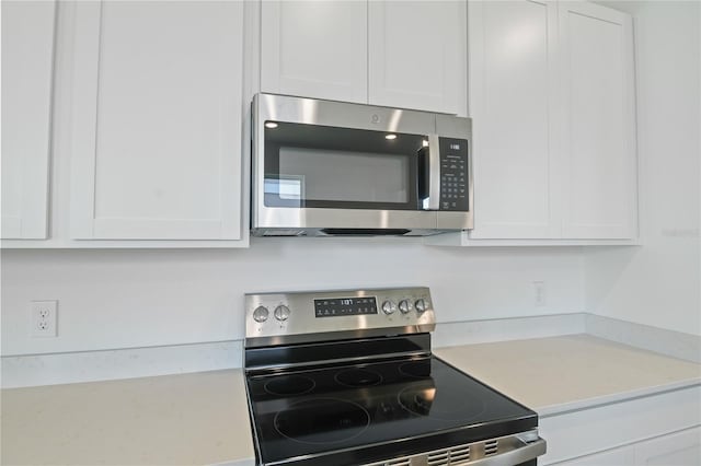 4079 Bannock Ave, Tavares, FL 32778 - kitchen with appliances with stainless steel finishes, light countertops, and white cabinets