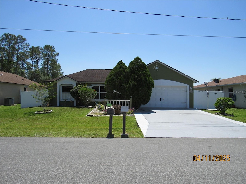 1155 Roan Ct, Kissimmee, FL 34759 - ranch-style home featuring central AC unit, a garage, fence, concrete driveway, and a front lawn
