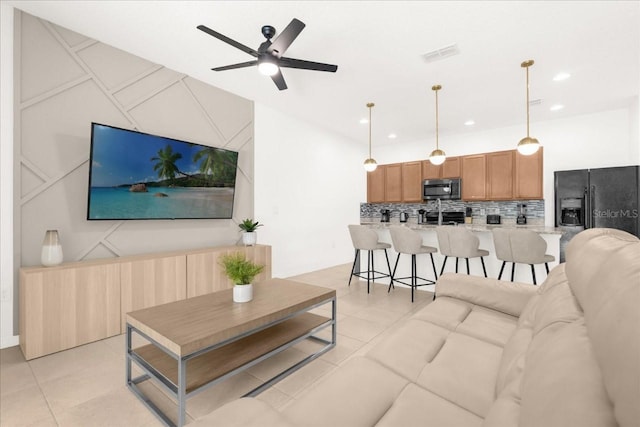 living room with a ceiling fan, recessed lighting, light tile patterned floors, and visible vents