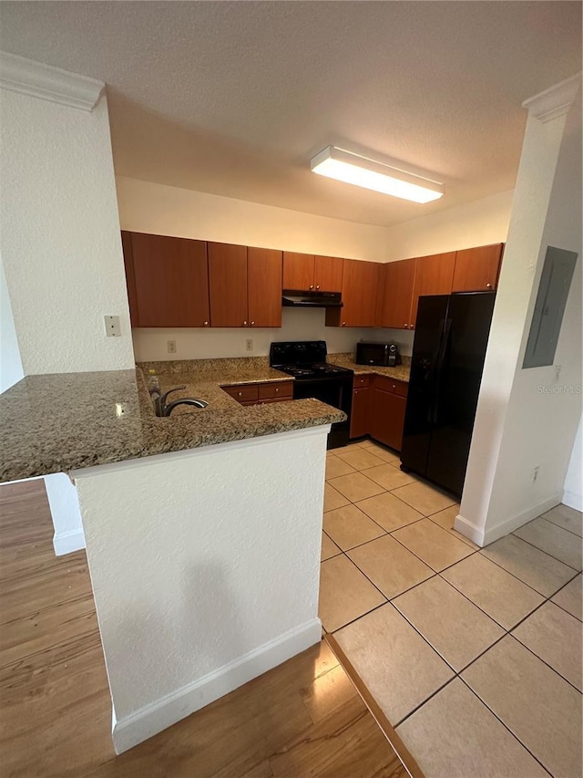 304 E S St Unit 5020, Orlando, FL 32801 - kitchen with electric panel, a sink, a peninsula, under cabinet range hood, and black appliances