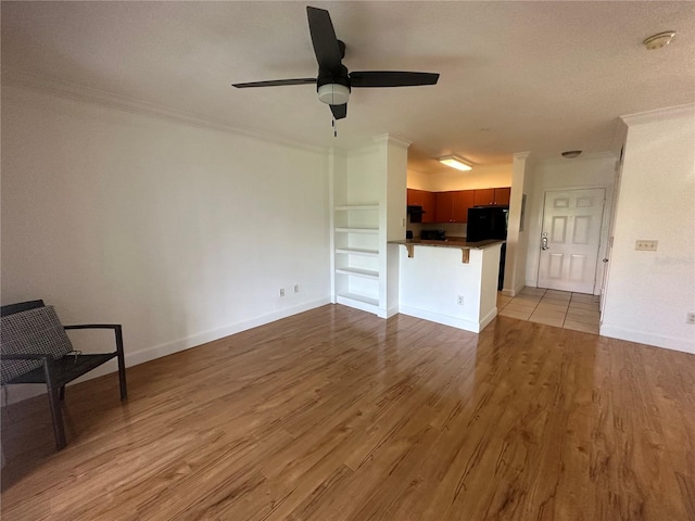 304 E S St Unit 5020, Orlando, FL 32801 - living room featuring crown molding, baseboards, built in shelves, light wood finished floors, and a ceiling fan