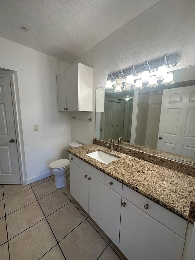 304 E S St Unit 5020, Orlando, FL 32801 - bathroom with a textured ceiling, baseboards, toilet, vanity, and tile patterned flooring
