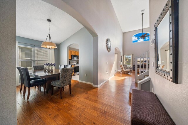 1048 Lake Berkley Dr, Kissimmee, FL 34746 - dining space with stairway, arched walkways, wood-type flooring, and baseboards