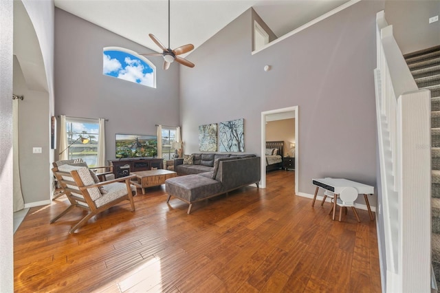 1048 Lake Berkley Dr, Kissimmee, FL 34746 - living area featuring high vaulted ceiling, ceiling fan, wood finished floors, stairs, and baseboards