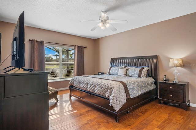 1048 Lake Berkley Dr, Kissimmee, FL 34746 - bedroom featuring a textured ceiling, wood finished floors, ceiling fan, and baseboards